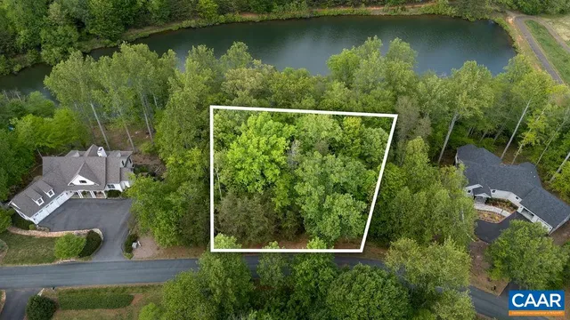 an aerial view of residential houses with outdoor space and lake view