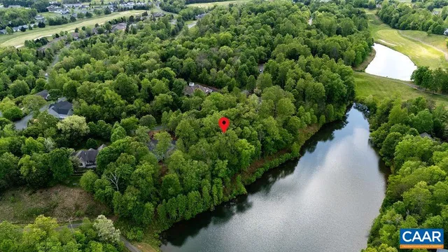 an aerial view of residential houses with outdoor space and lake view