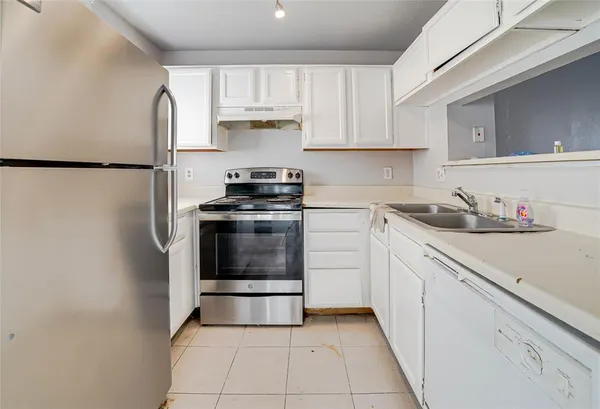 a kitchen with a stove top oven and cabinets