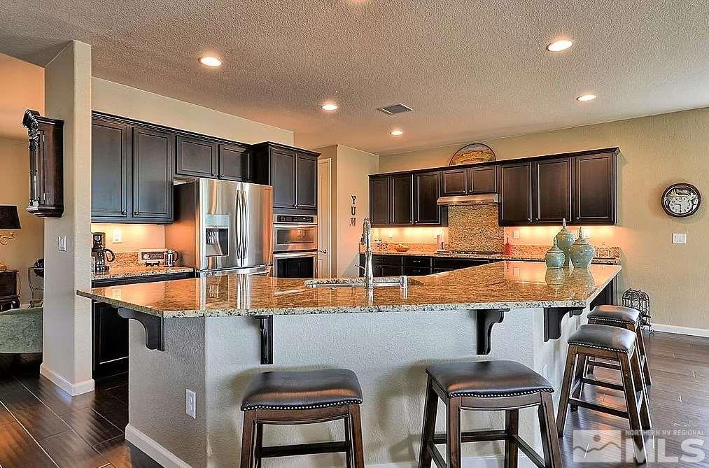 1650 Back Nine Trail Reno, NV 89523 - Photo 2 of 4 a kitchen with stainless steel appliances granite countertop a table chairs sink refrigerator and microwave