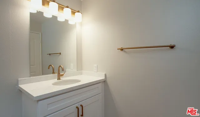 a bathroom with a sink vanity and a mirror