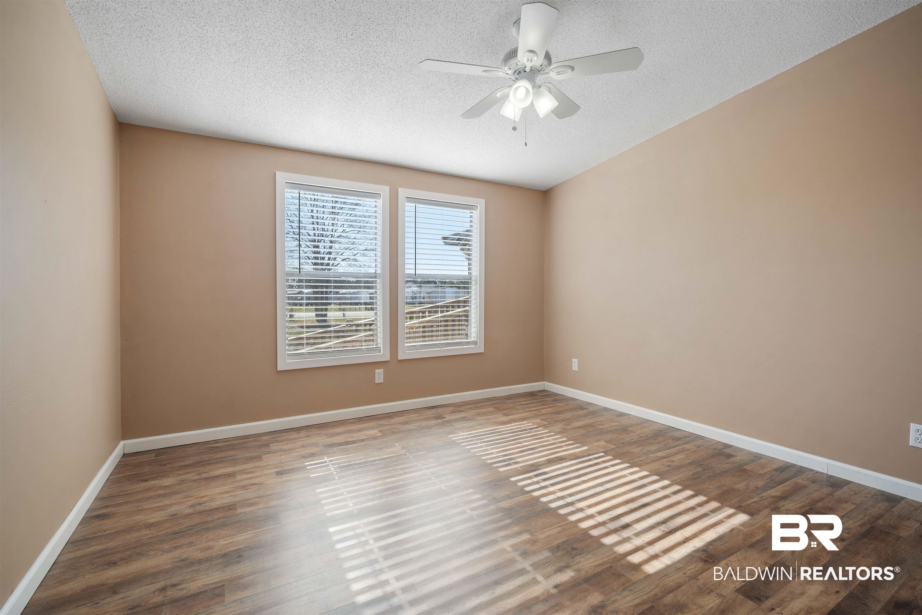 9011 Wilmer Georgetown Road Wilmer, AL 36587 - Photo 22 of 34 Unfurnished room with wood finished floors, a textured ceiling, baseboards, and ceiling fan