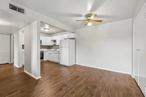 a view of empty room with wooden floor
