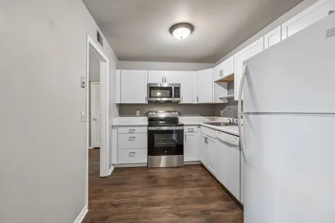 a kitchen with stainless steel appliances granite countertop a refrigerator and a stove top oven