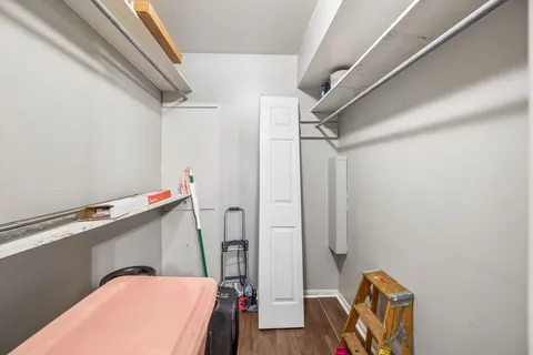 a view of walk in closet with clothes and shoes