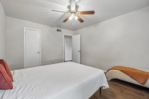 a bedroom with a bed and a ceiling fan