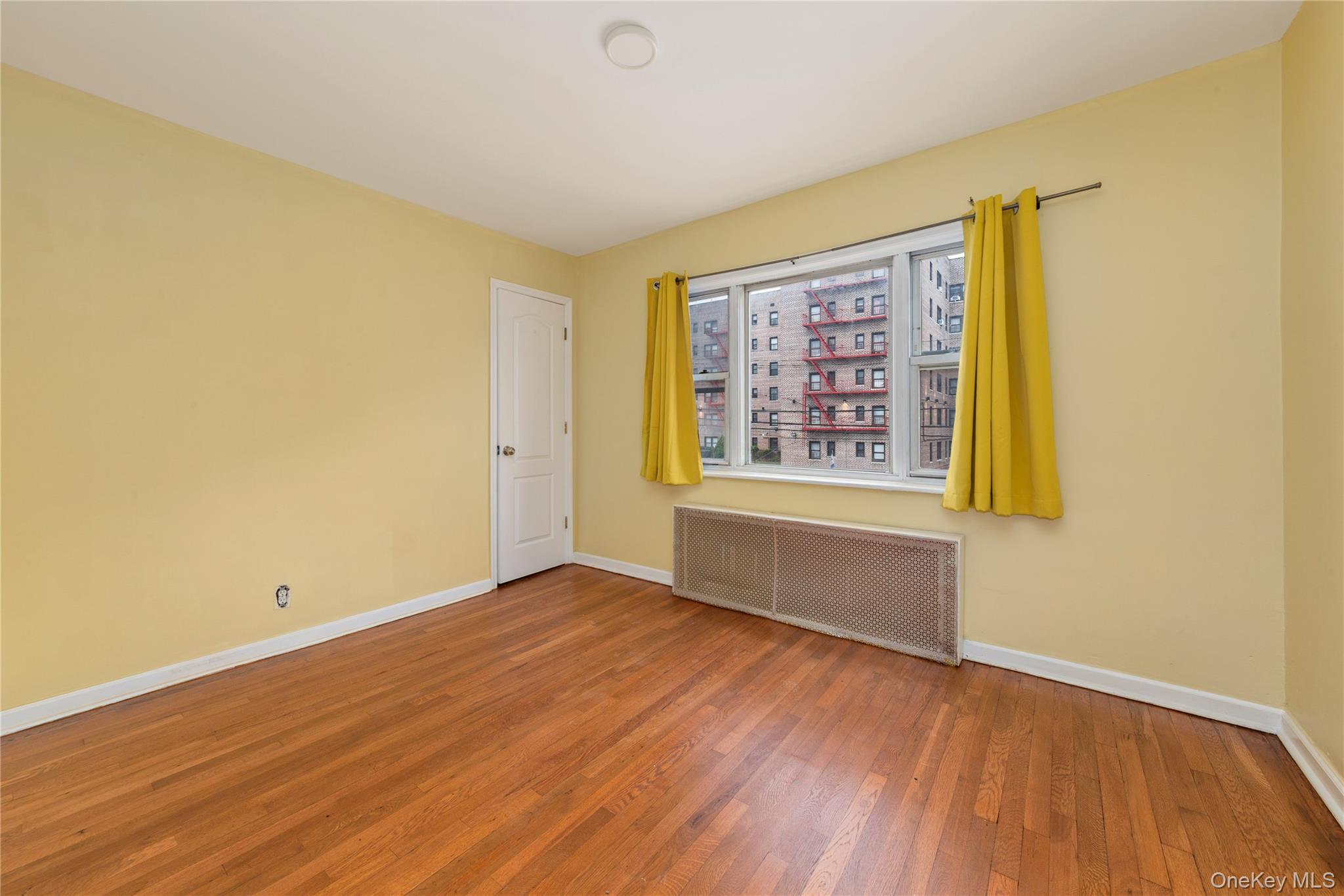 91-41 195th Street Queens, NY 11423 - Photo 13 of 31 an empty room with wooden floor and windows
