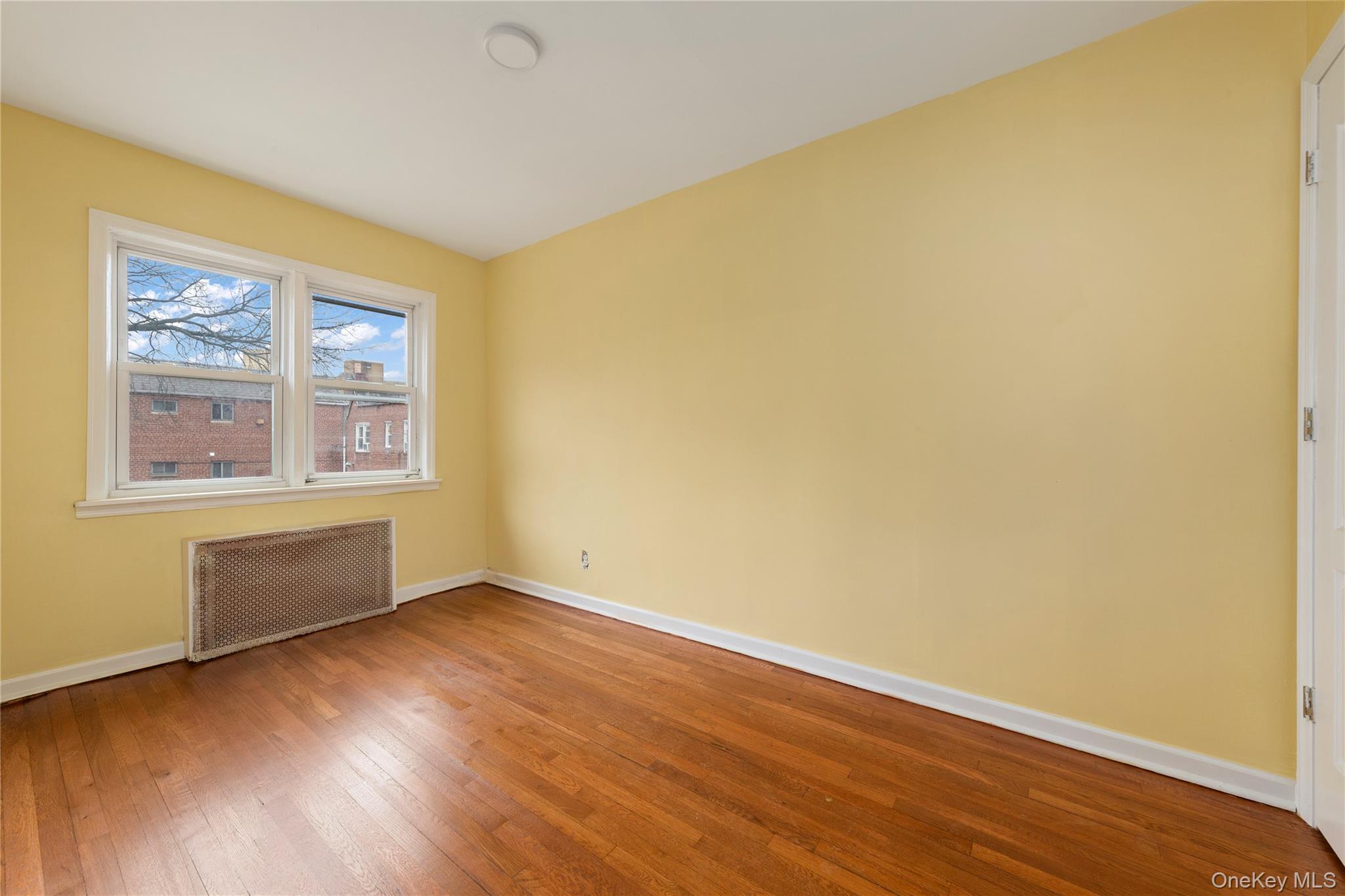 91-41 195th Street Queens, NY 11423 - Photo 14 of 31 a view of an empty room with wooden floor and a window