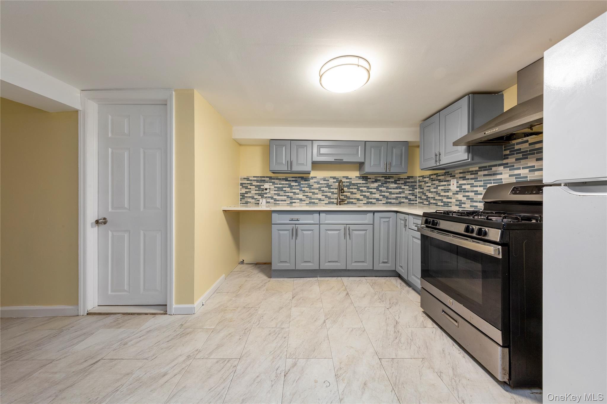 91-41 195th Street Queens, NY 11423 - Photo 23 of 31 a kitchen with stainless steel appliances a stove a sink and a refrigerator