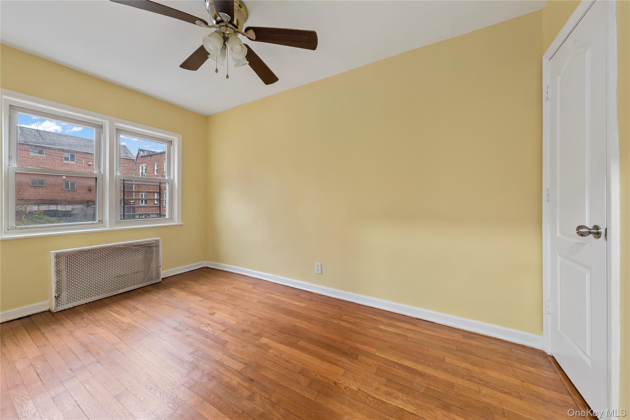 91-41 195th Street Queens, NY 11423 - Photo 5 of 31 a view of an empty room with window and wooden floor