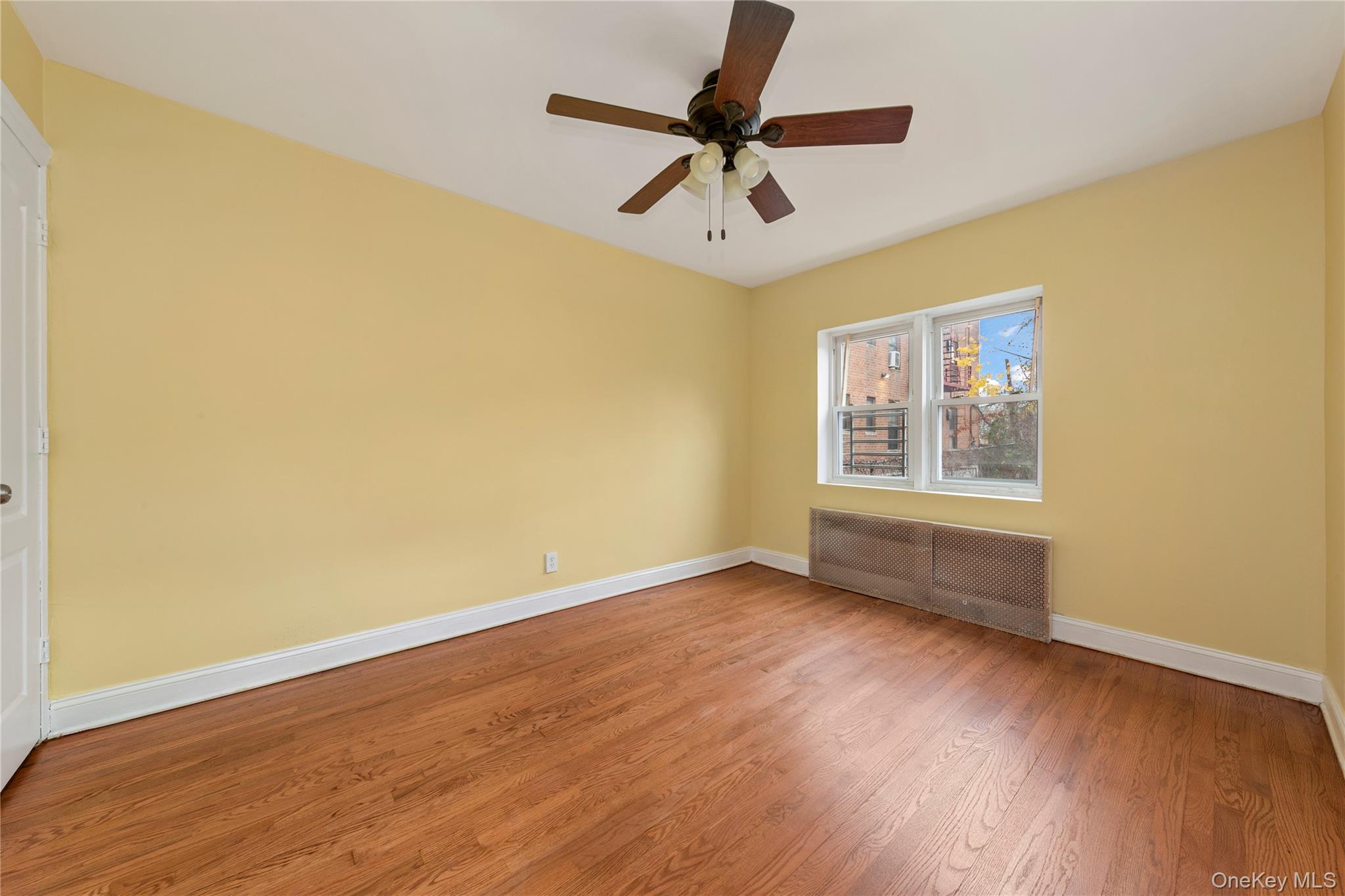 91-41 195th Street Queens, NY 11423 - Photo 6 of 31 a view of an empty room with wooden floor and a window