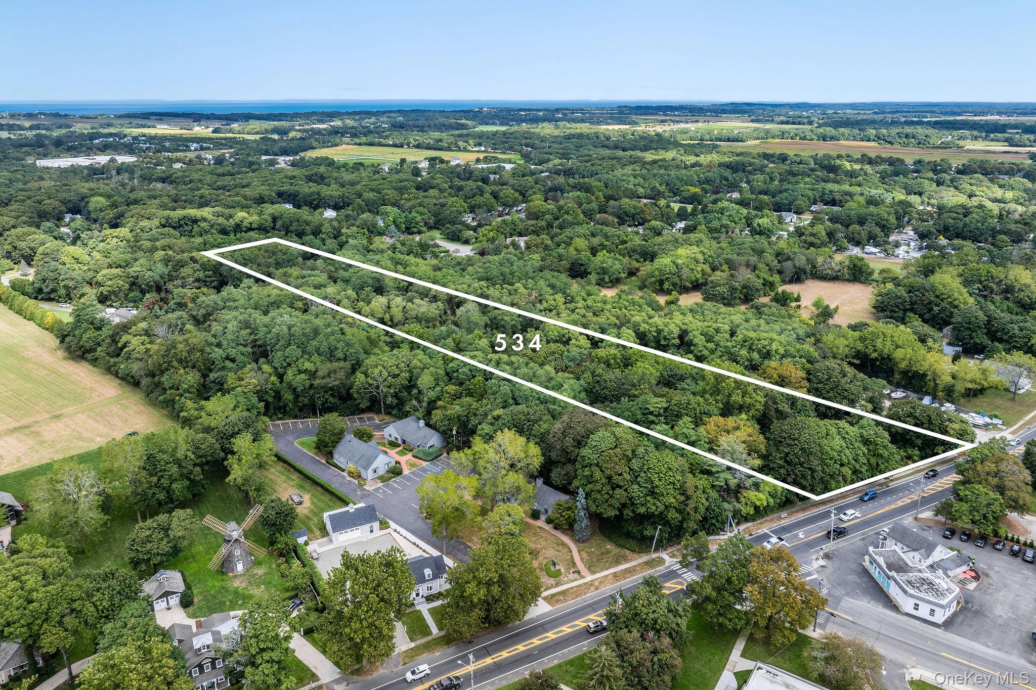 534 Main Road Aquebogue, NY 11901 - Photo 4 of 6 Aerial overview of property's location with a heavily wooded area and property boundaries highlighted