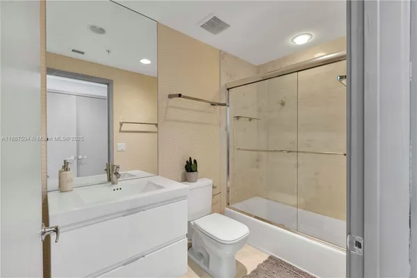 a large bedroom with a bed and wooden floor