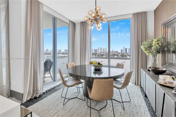 a living room with stainless steel appliances furniture a rug and a view of kitchen