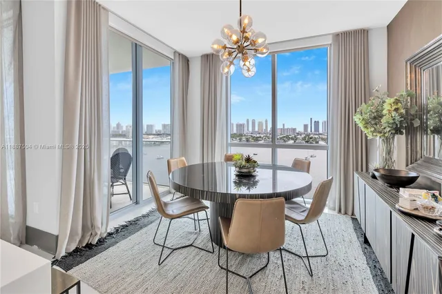 a living room with stainless steel appliances furniture a rug and a view of kitchen