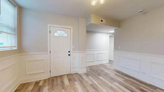 a view of empty room with wooden floor and entryway