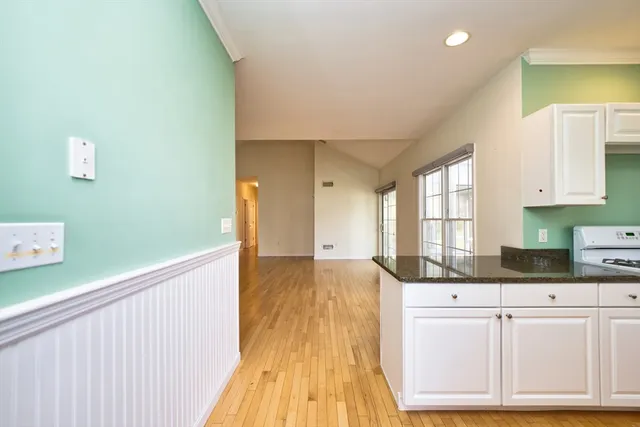a kitchen with granite countertop a sink window and cabinets