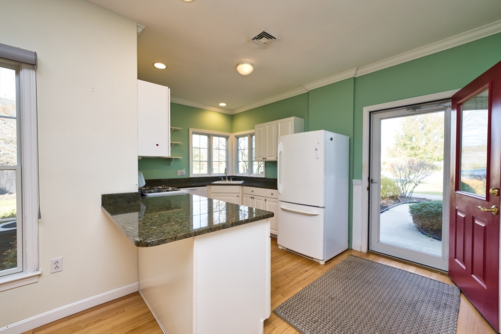 8 Village Way, Unit 8 Westport, MA 02790 - Photo 14 of 29 a kitchen with granite countertop a refrigerator and a stove top oven