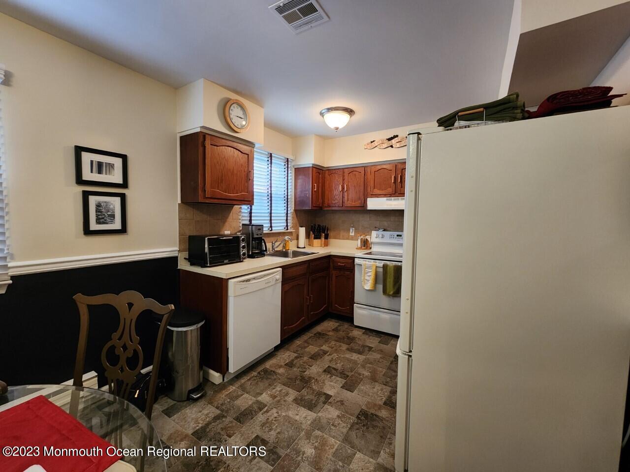 21 B Medford Road Whiting, NJ 08759 - Photo 3 of 21 a kitchen with a refrigerator a stove top oven a sink and a microwave