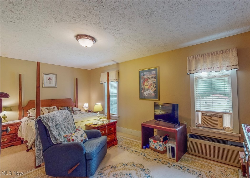 5696 Steubenville Road Southeast Amsterdam, OH 43903 - Photo 31 of 50 Bedroom with a textured ceiling, cooling unit, a wall mounted air conditioner, and carpet