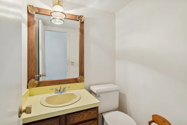 a bathroom with a granite countertop sink toilet and mirror