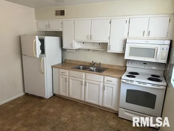 a kitchen with cabinets and appliances