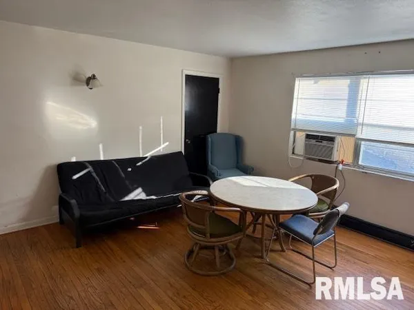 a living room with furniture a window and wooden floor