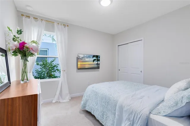 a bedroom with a bed and a potted plant