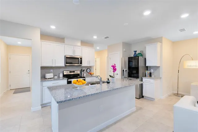 a kitchen with sink refrigerator and microwave