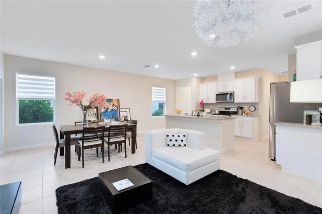 a living room with furniture and kitchen view with wooden floor