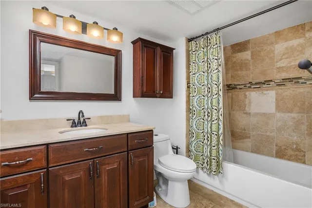 a bathroom with a toilet a sink a mirror a bathtub and shower