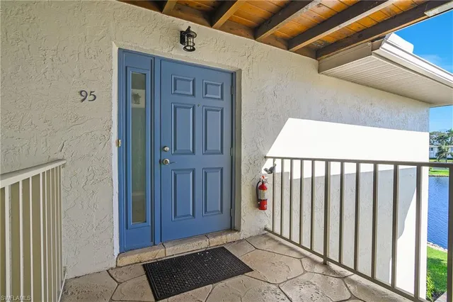 a view of a street with a couple of cars parked in front of house
