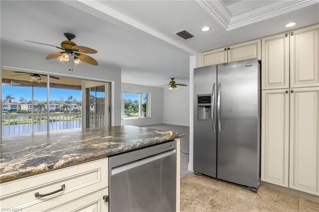 a kitchen with granite countertop a refrigerator and a sink