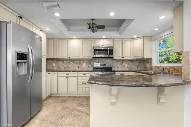 a kitchen with kitchen island a counter space a sink appliances and cabinets