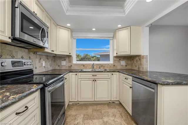 a kitchen with stainless steel appliances granite countertop a stove a sink and a microwave