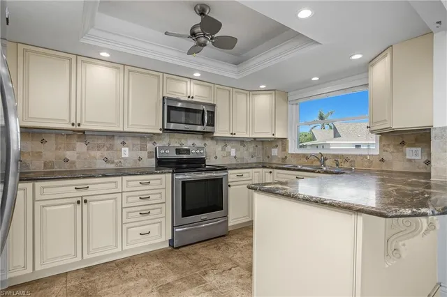 a kitchen with stainless steel appliances granite countertop a stove sink microwave and cabinets