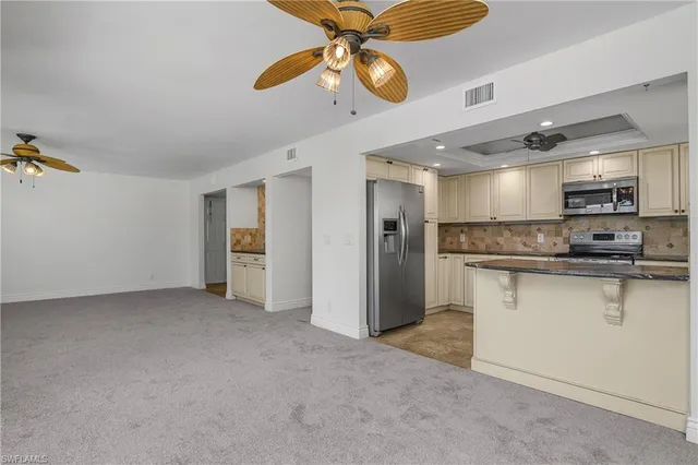 a view of kitchen with stainless steel appliances granite countertop cabinets and window