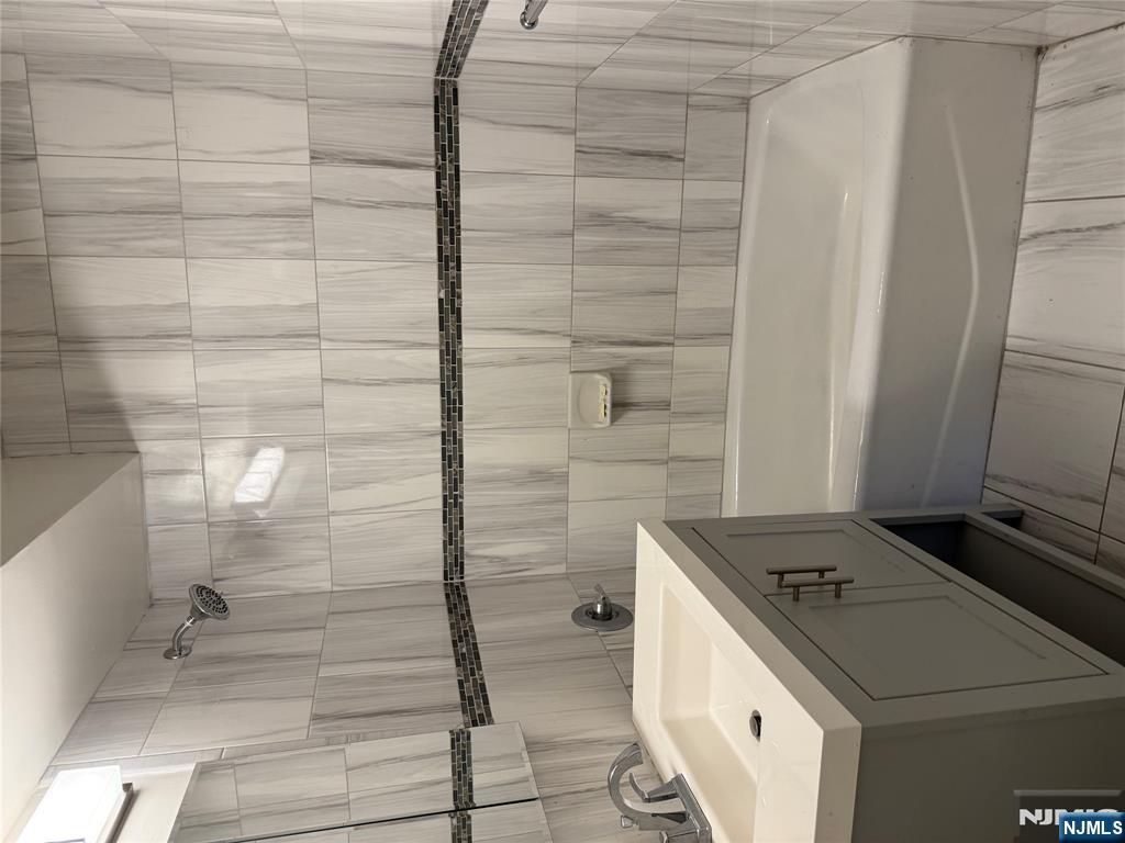 873 Main Street, Unit 2C Hackensack, NJ 07601 - Photo 8 of 11 a bathroom with a bathtub and shower