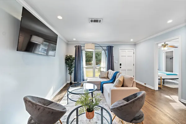 a living room with furniture a rug and kitchen view