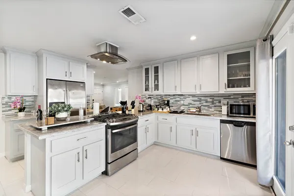 a kitchen with white cabinets and white appliances