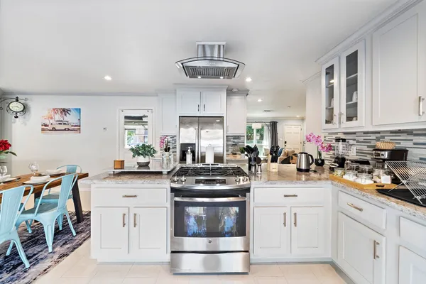 a kitchen with stainless steel appliances granite countertop a stove sink and cabinets