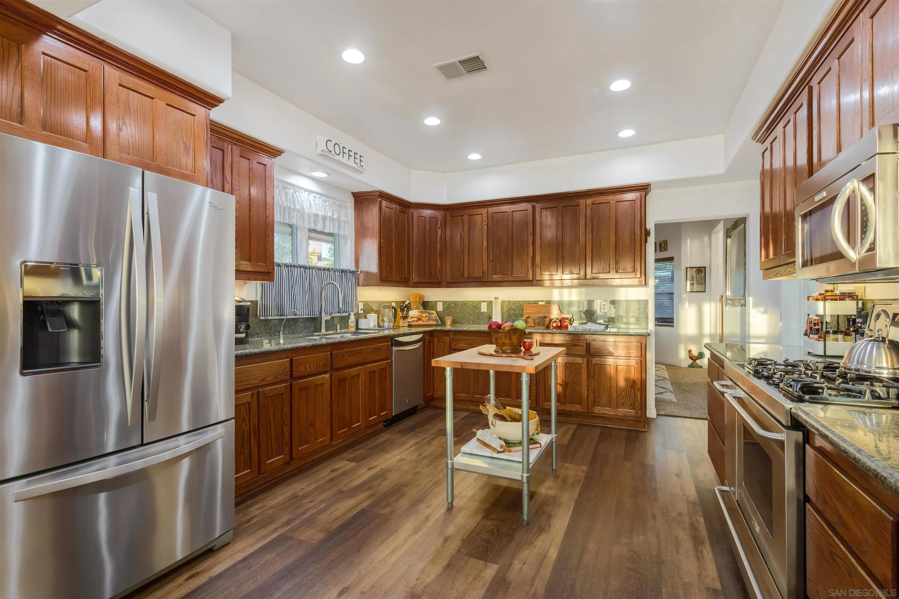 1210 Lakedale Road Santa Ysabel, CA 92070 - Photo 5 of 67 a kitchen with stainless steel appliances granite countertop a refrigerator a stove top oven a sink dishwasher and white cabinets with wooden floor