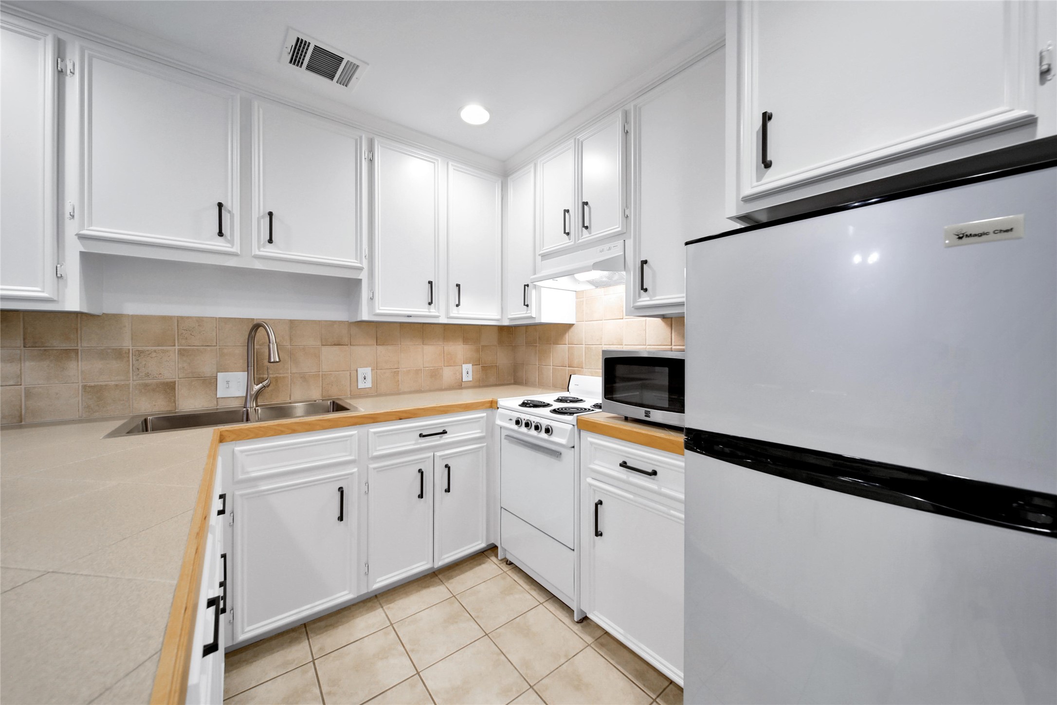 520 West 15th Street Houston, TX 77008 - Photo 14 of 22 a kitchen with granite countertop white cabinets and white appliances