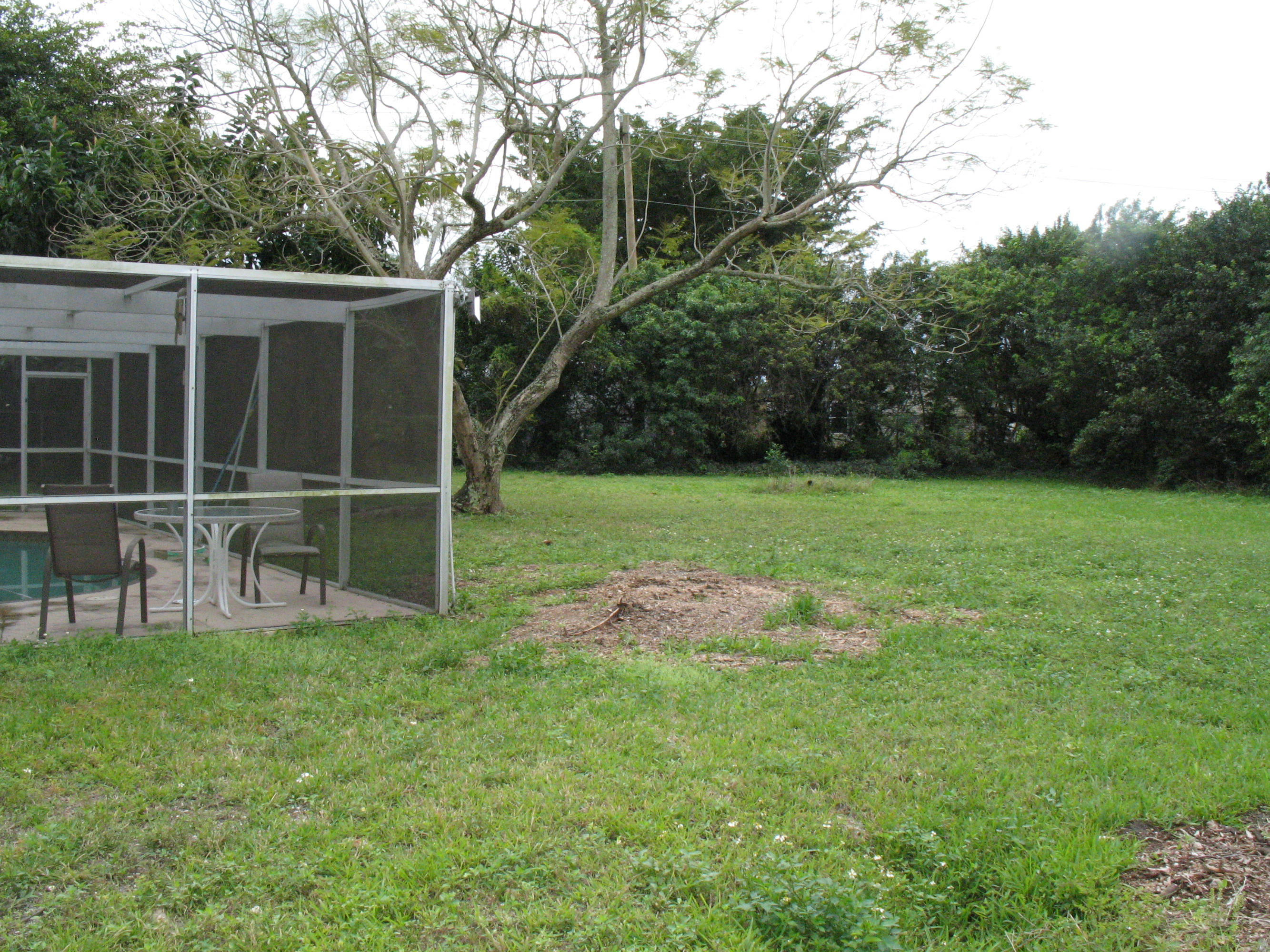 10213 Sleepy Brook Way Boca Raton, FL 33428 - Photo 4 of 15 a view of a backyard with table and chairs potted plants and large tree