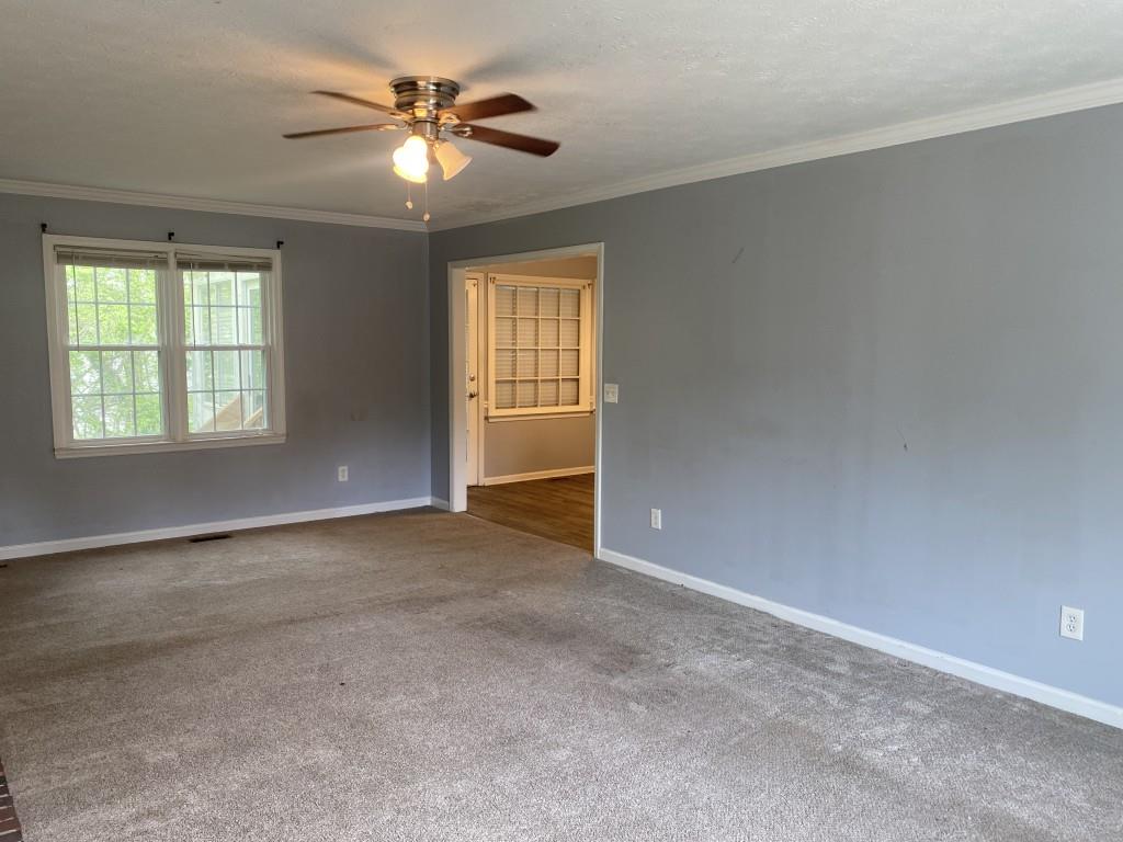 4749 Shallow Ridge Road Northeast Kennesaw, GA 30144 - Photo 4 of 28 an empty room with windows and ceiling fan