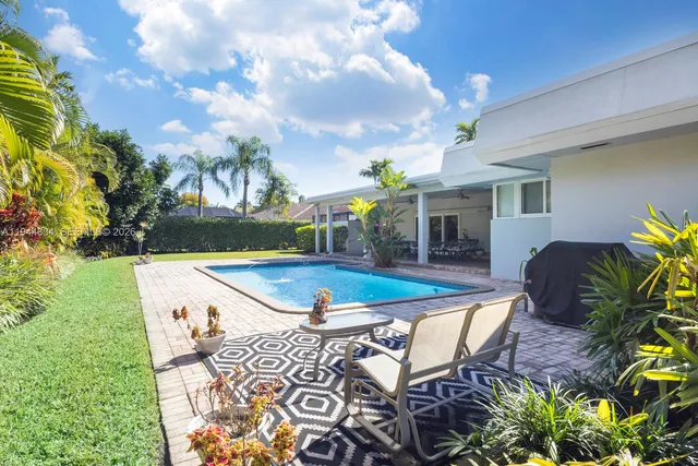 an aerial view of a house with swimming pool and mountains