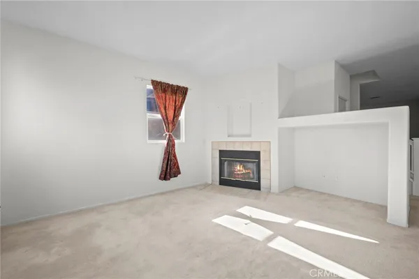 a view of a livingroom with a staircase and kitchen space