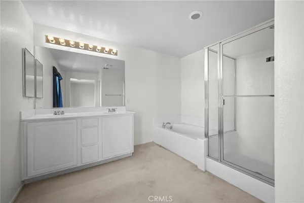 a spacious bathroom with a shower a mirror and a sink