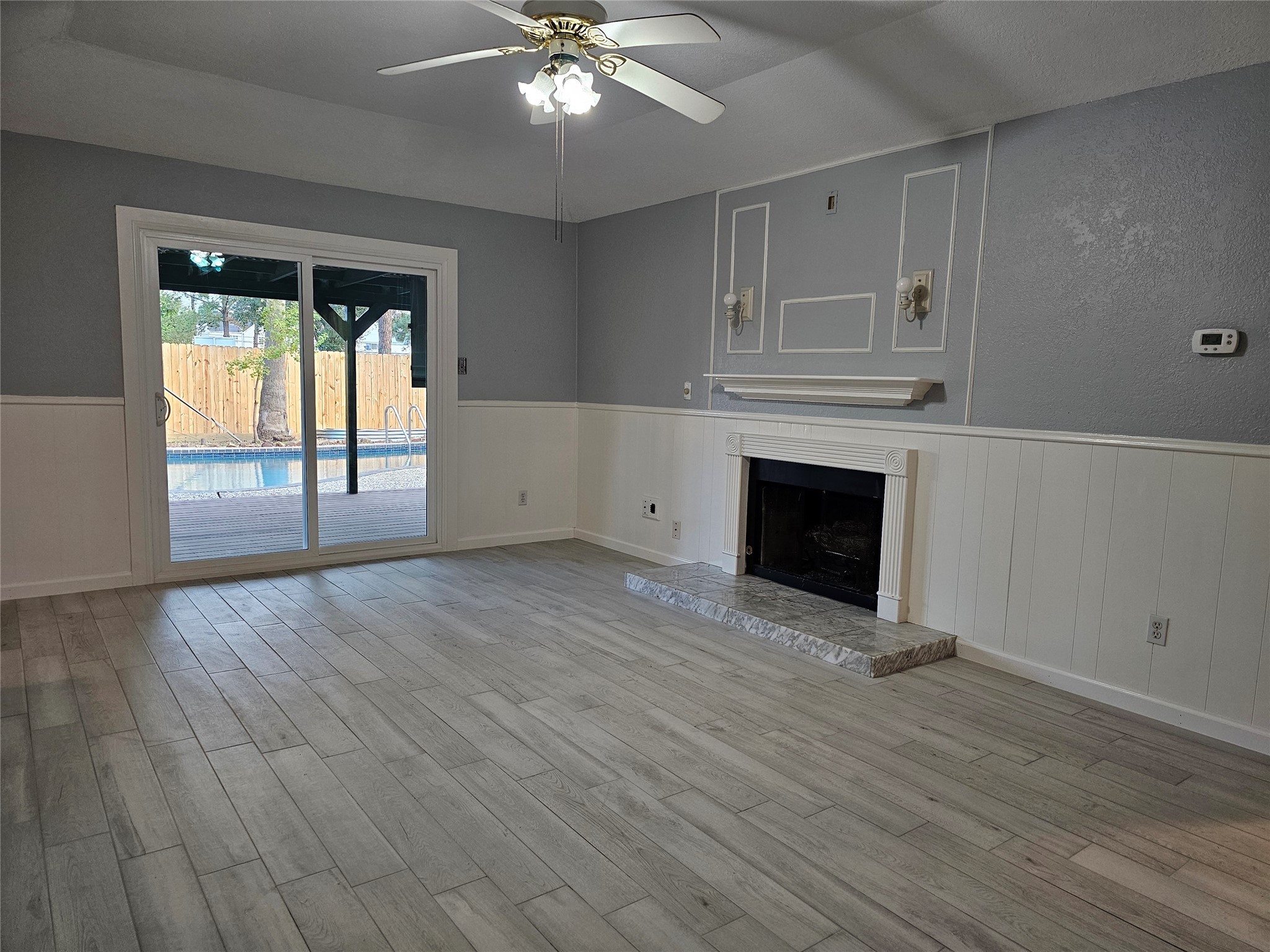 2502 Knoll Street Houston, TX 77080 - Photo 13 of 38 an empty room with wooden floor fireplace and windows