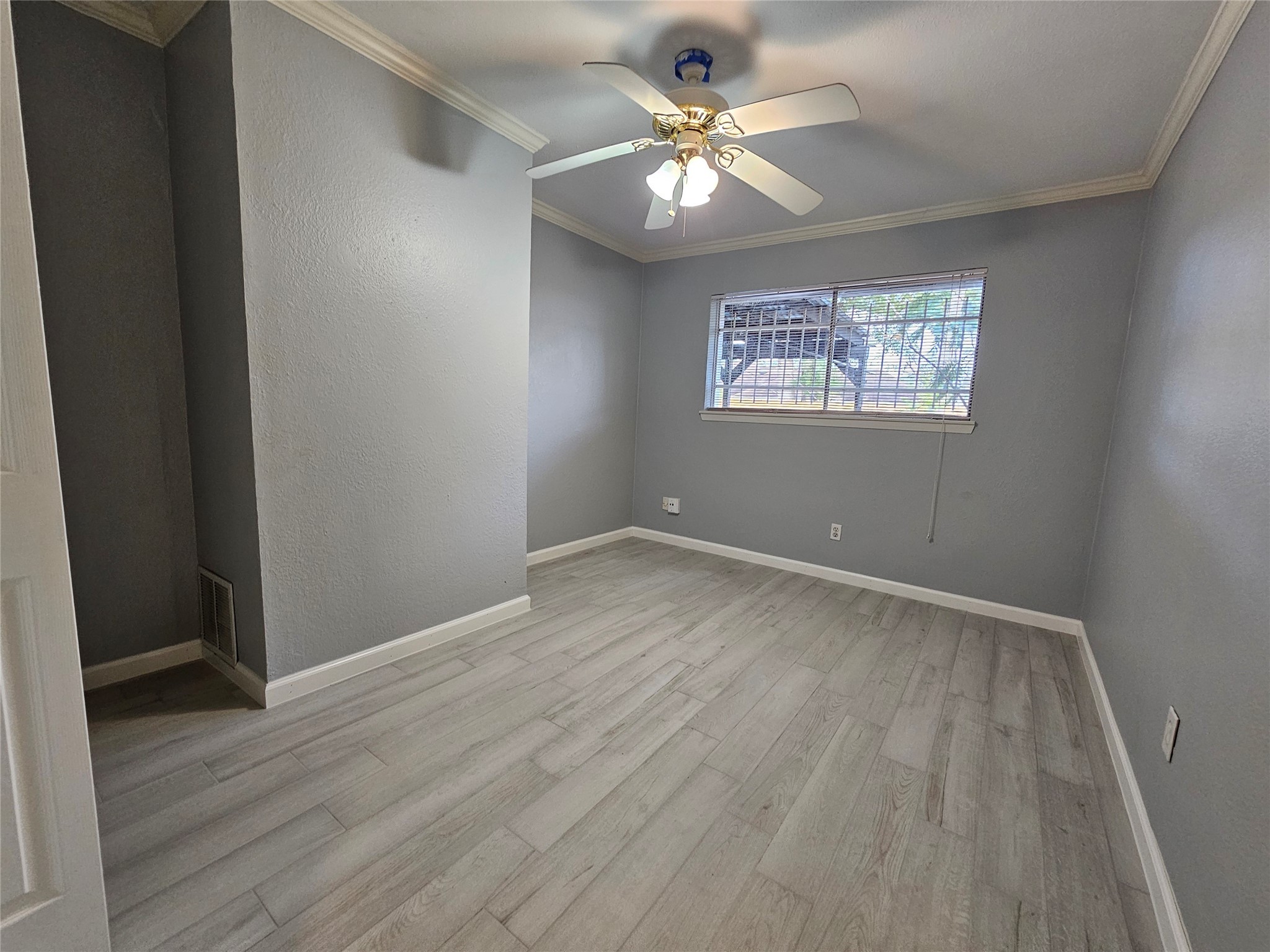 2502 Knoll Street Houston, TX 77080 - Photo 26 of 38 an empty room with wooden floor chandelier fan and windows